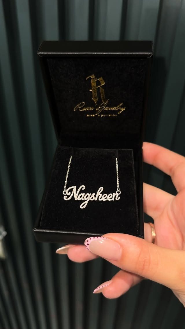 Silver nameplate necklace reading Nagsheen inside a black velvet jewelry box