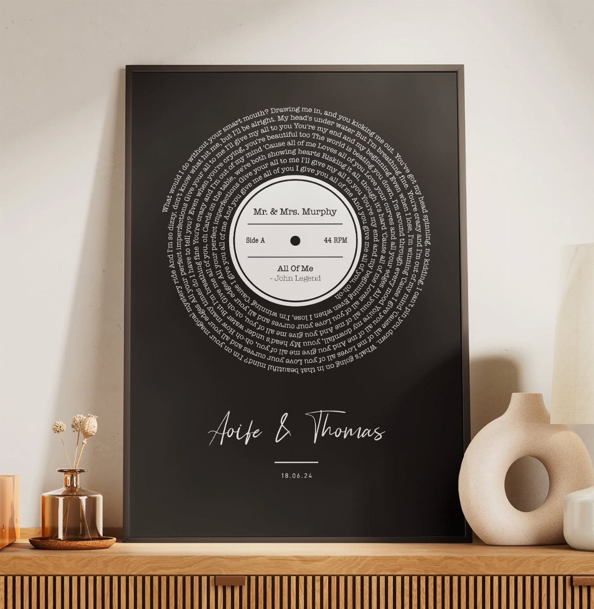 Framed black print with song lyrics arranged in a vinyl record shape.