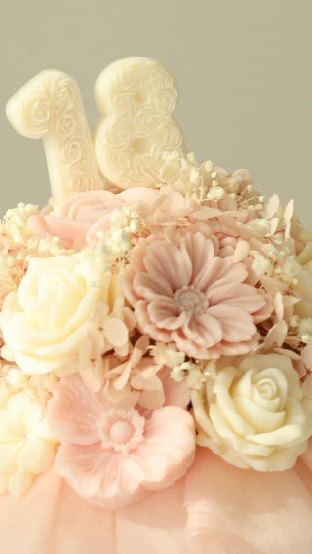 Floral wax candles in pink and cream with a number 18 topper.