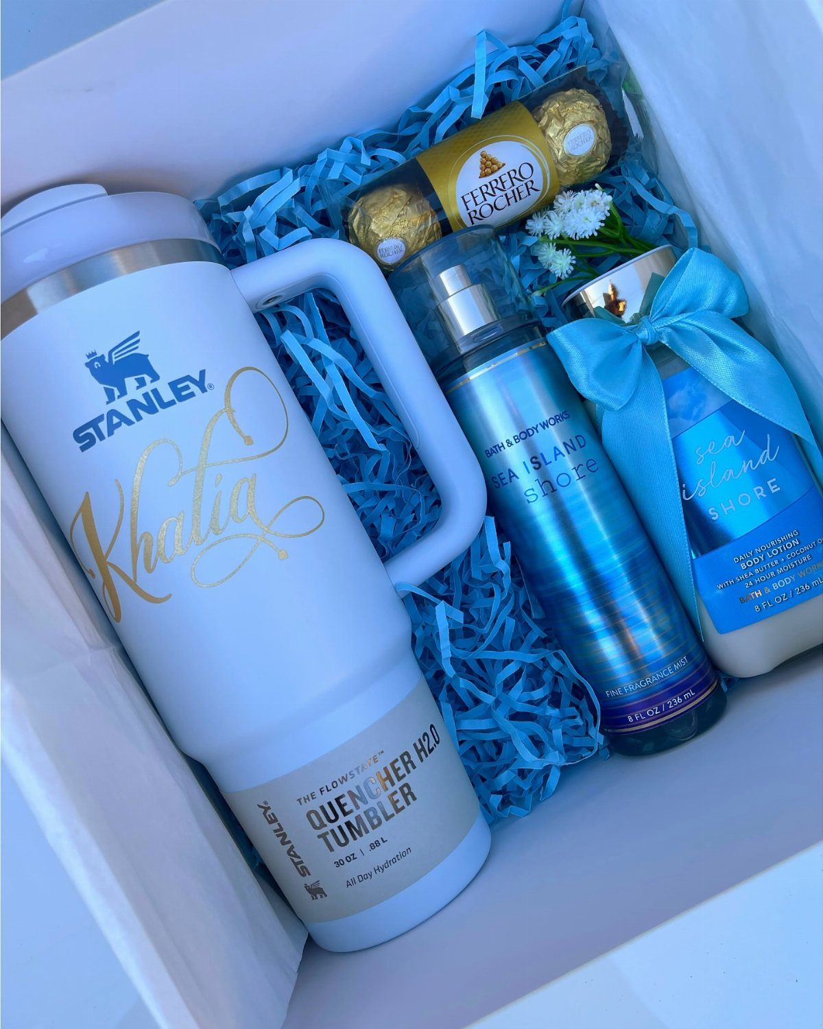 Light blue Stanley Quencher tumbler in a gift box with beauty products and chocolates.