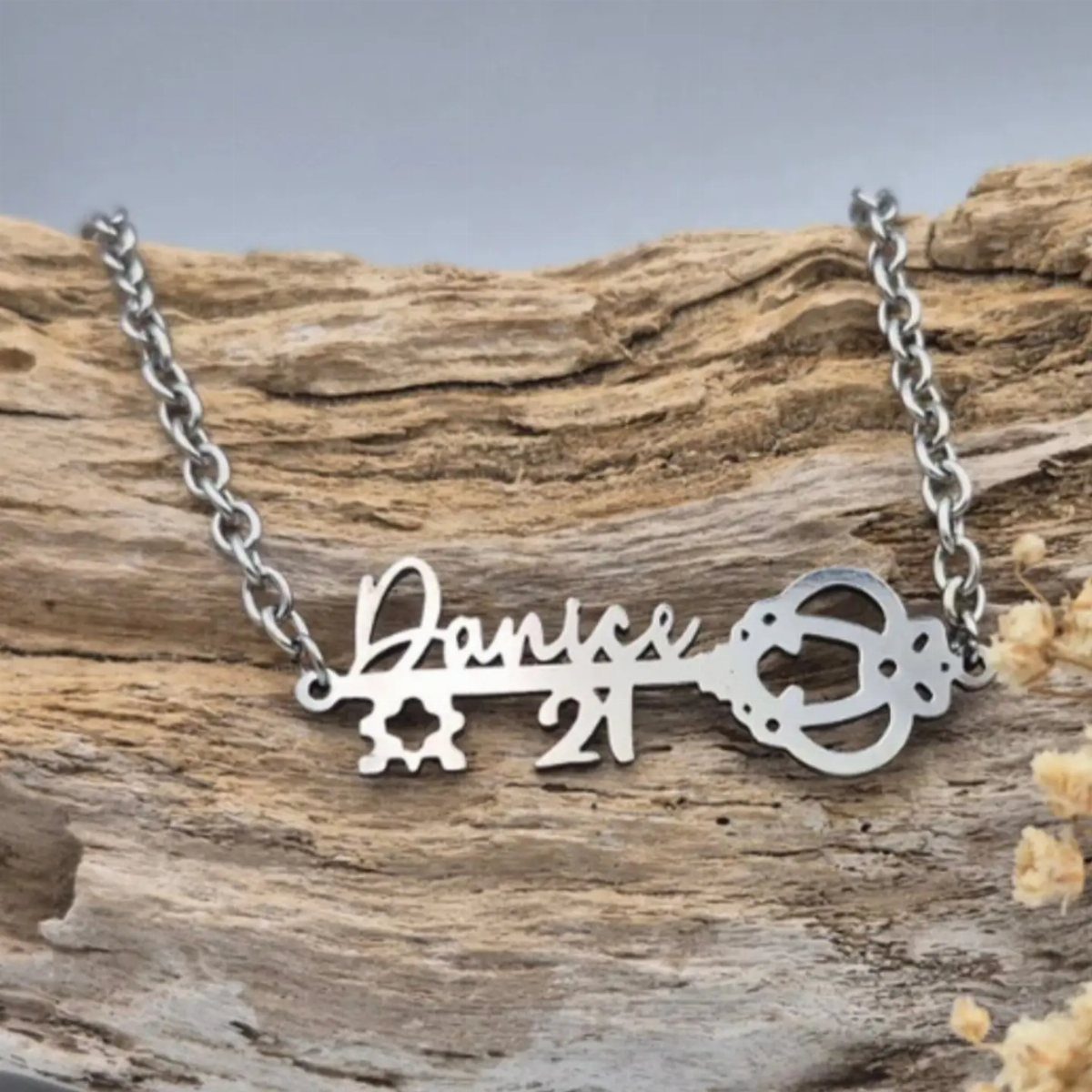 Silver key necklace with name Danice and number 21 on driftwood