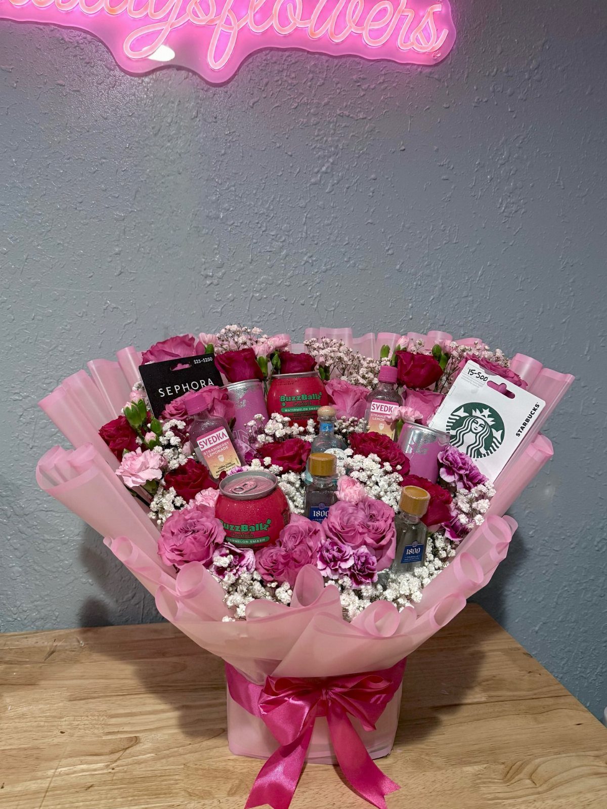 Floral bouquet with pink roses and embedded beauty products and gift cards.