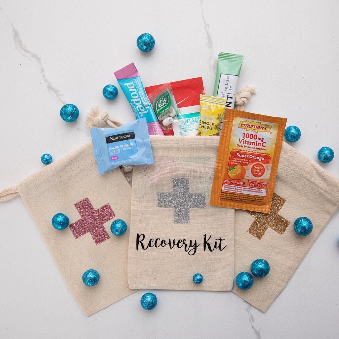 Three beige recovery kit bags with medicine packets and blue glittery spheres.