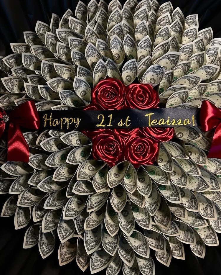Money bouquet made of folded dollar bills with red roses and birthday ribbon.