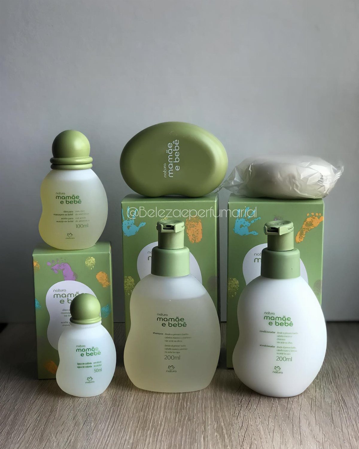 Baby skincare set with bottles and soap in green packaging on wooden surface