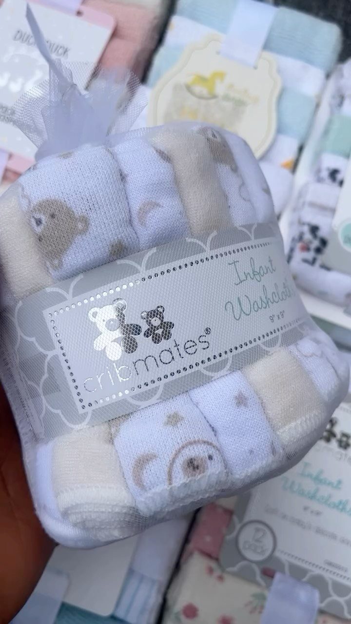 Packaged set of rolled white infant washcloths with cute bear and moon patterns.