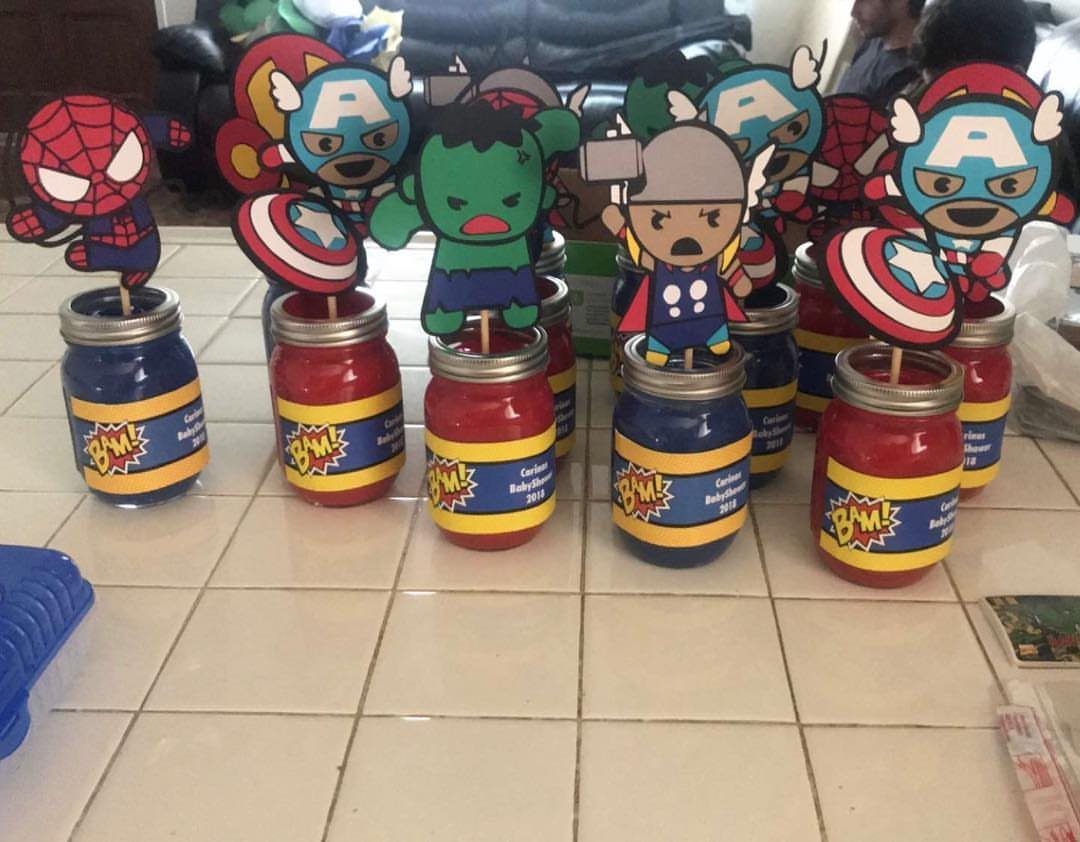Superhero themed baby shower jars with cartoon cutouts of Marvel characters on white tiles