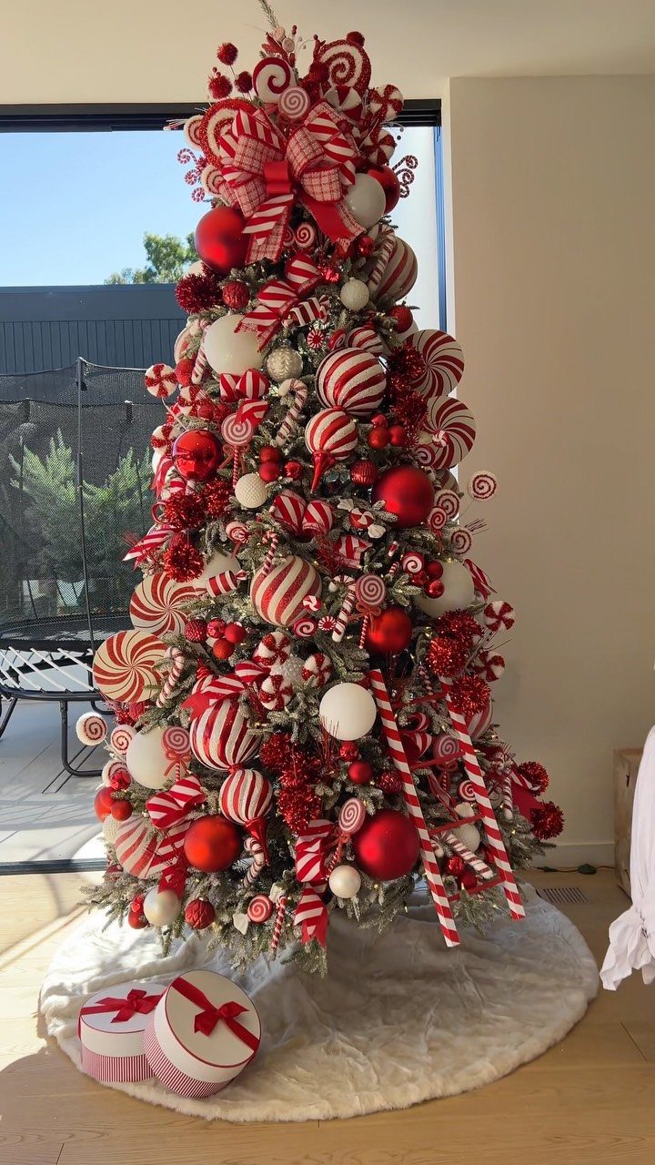 Christmas tree decorated with red and white candy cane striped ornaments and baubles.