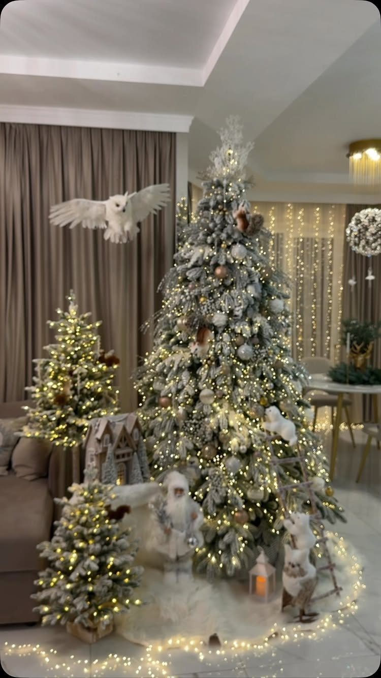 Flocked Christmas tree with silver ornaments and warm lights in a living room