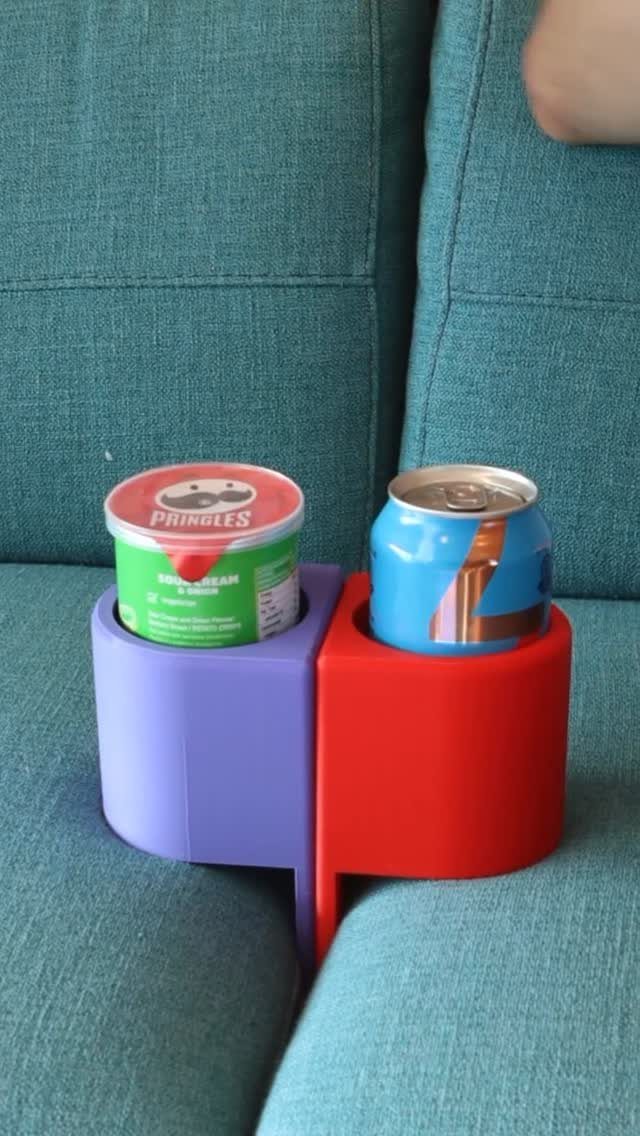 Purple and red couch cup holder tray holding Pringles and a blue can.