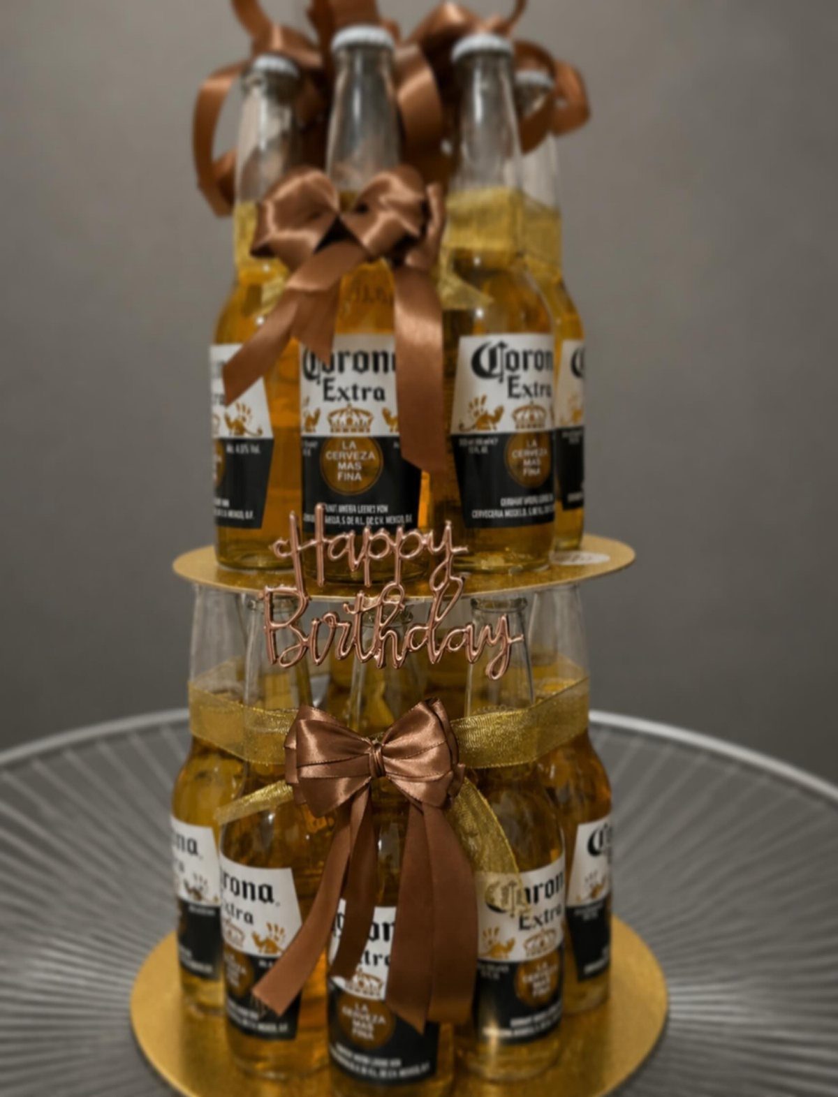 Beer bottle cake made of Corona Extra bottles with brown bows and birthday topper