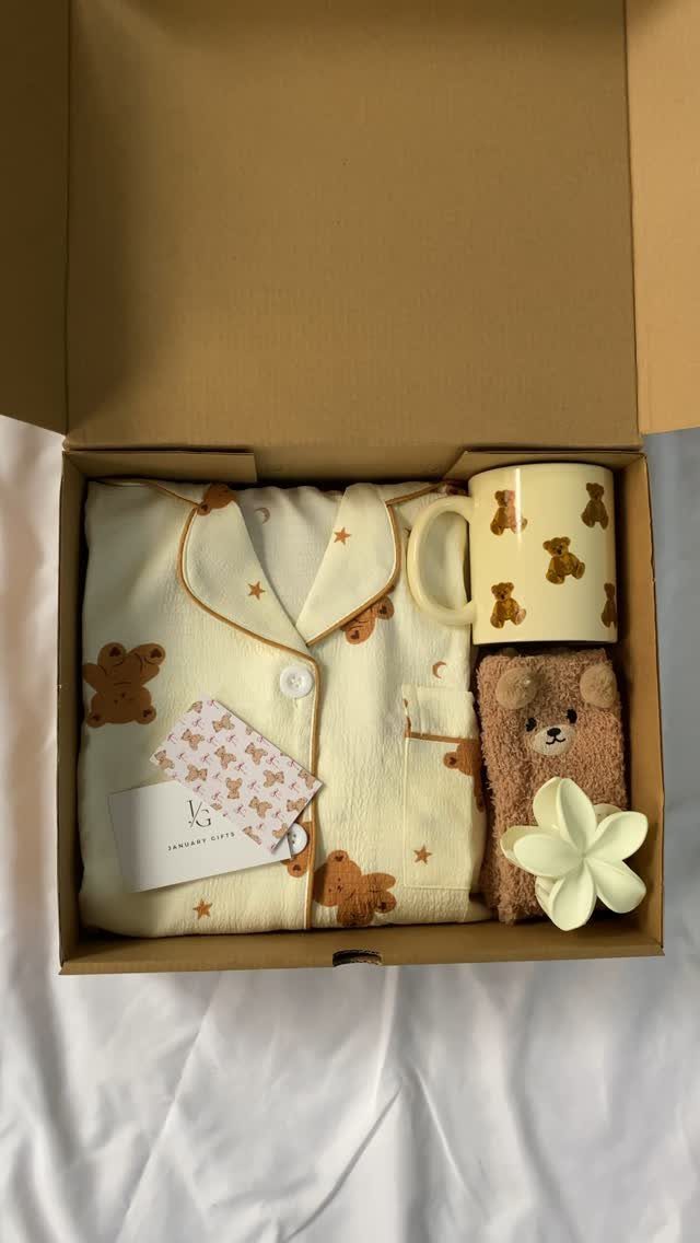 Gift box with bear-patterned pajamas, a matching mug, and a small teddy bear.