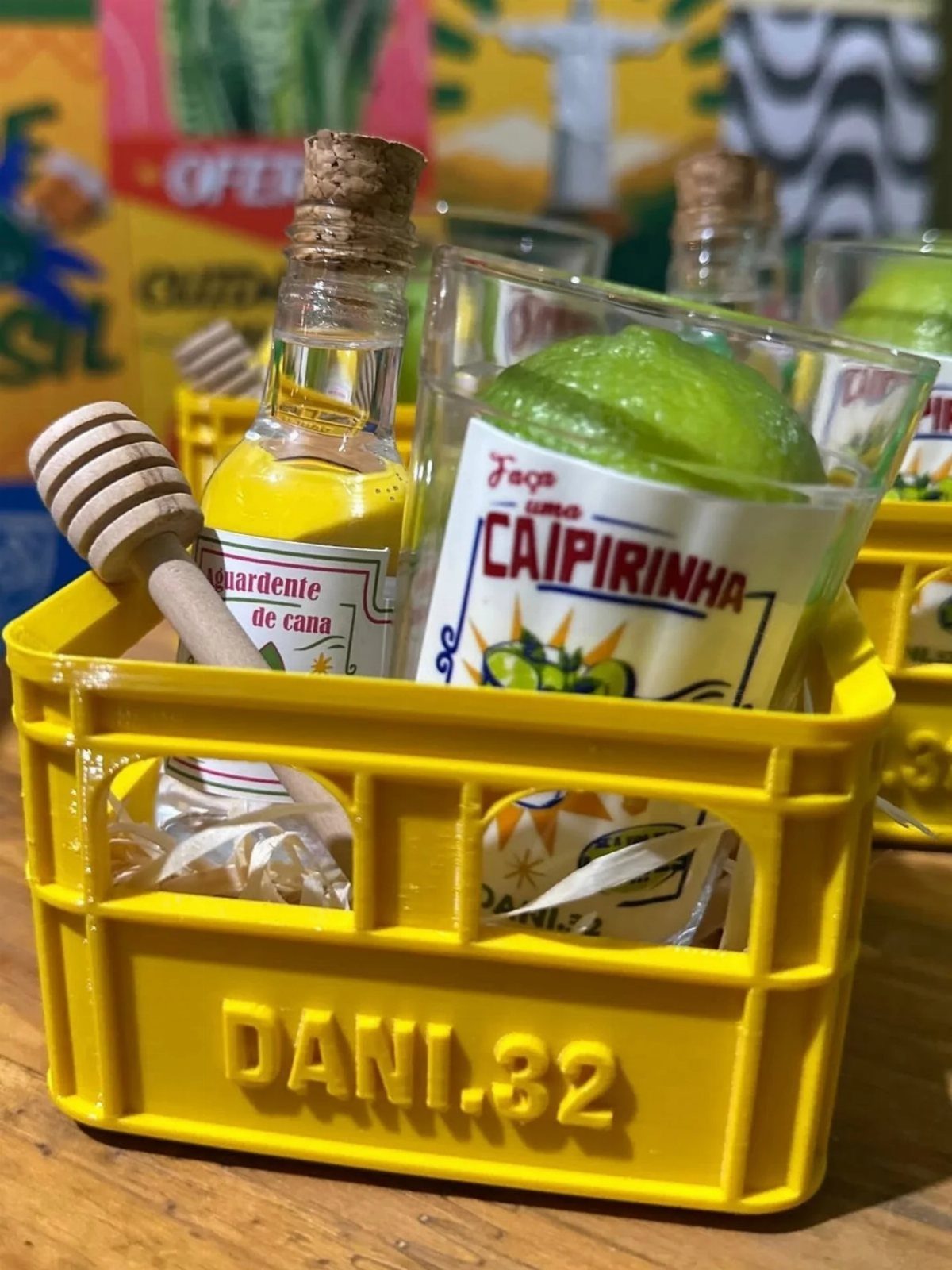 Yellow gift crate containing a Caipirinha cocktail kit with ingredients and honey dipper.