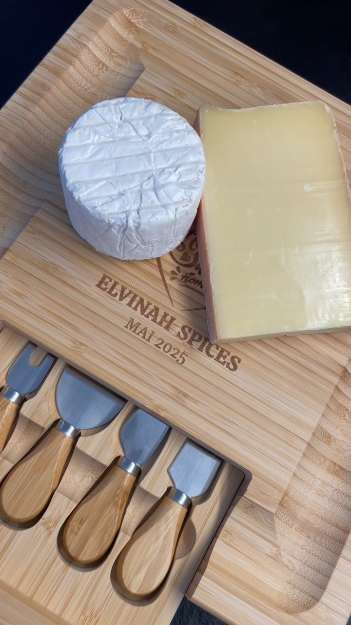Engraved bamboo cheese board with brie, hard cheese, and four cheese knives.