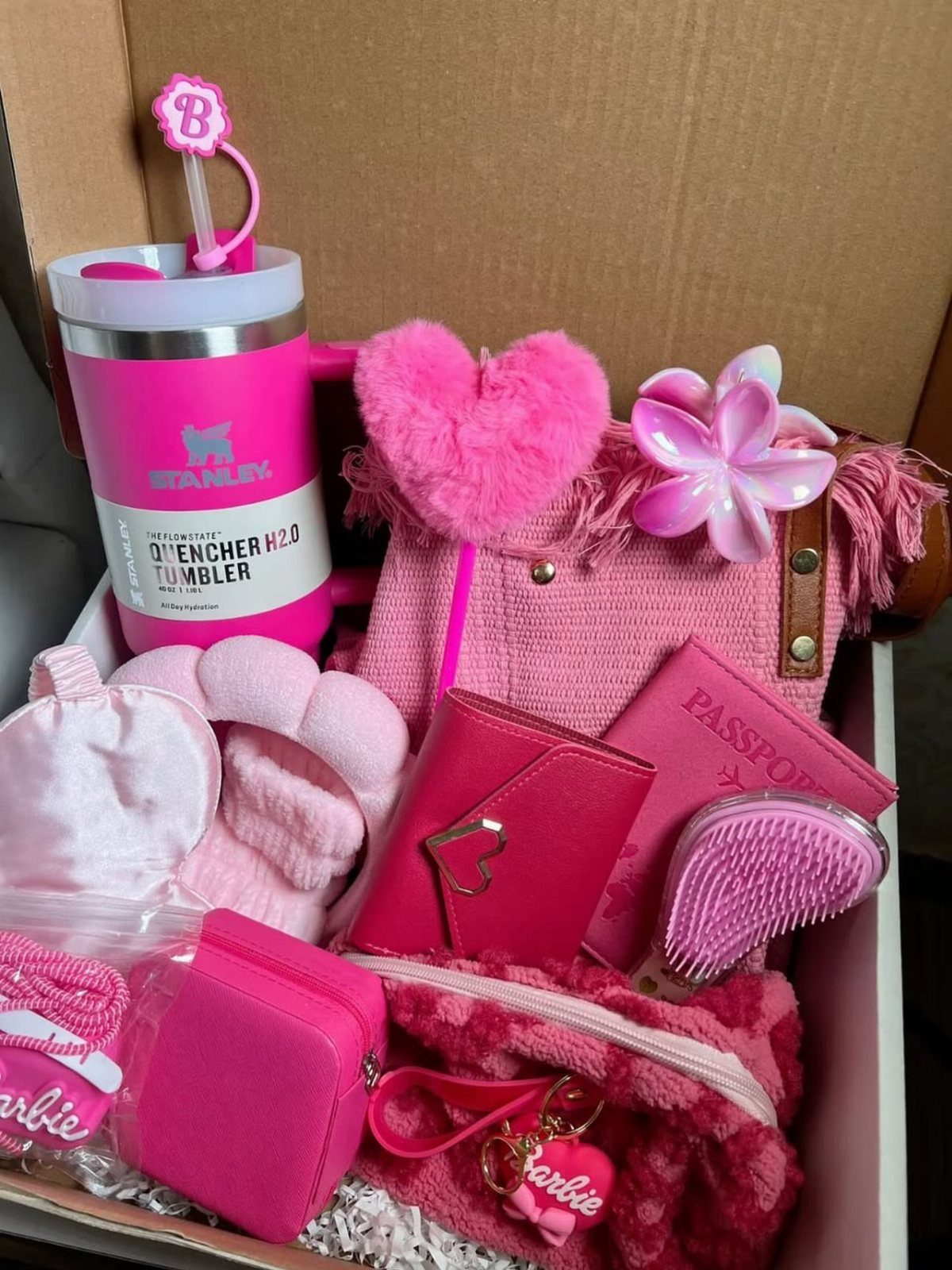 Pink themed gift box containing a tumbler, handbag, wallet, and beauty accessories.