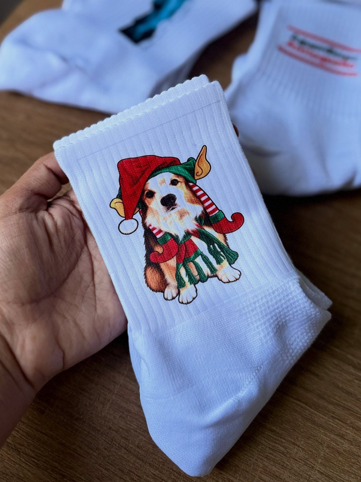 White sock featuring a printed Corgi dog wearing a festive Santa hat.