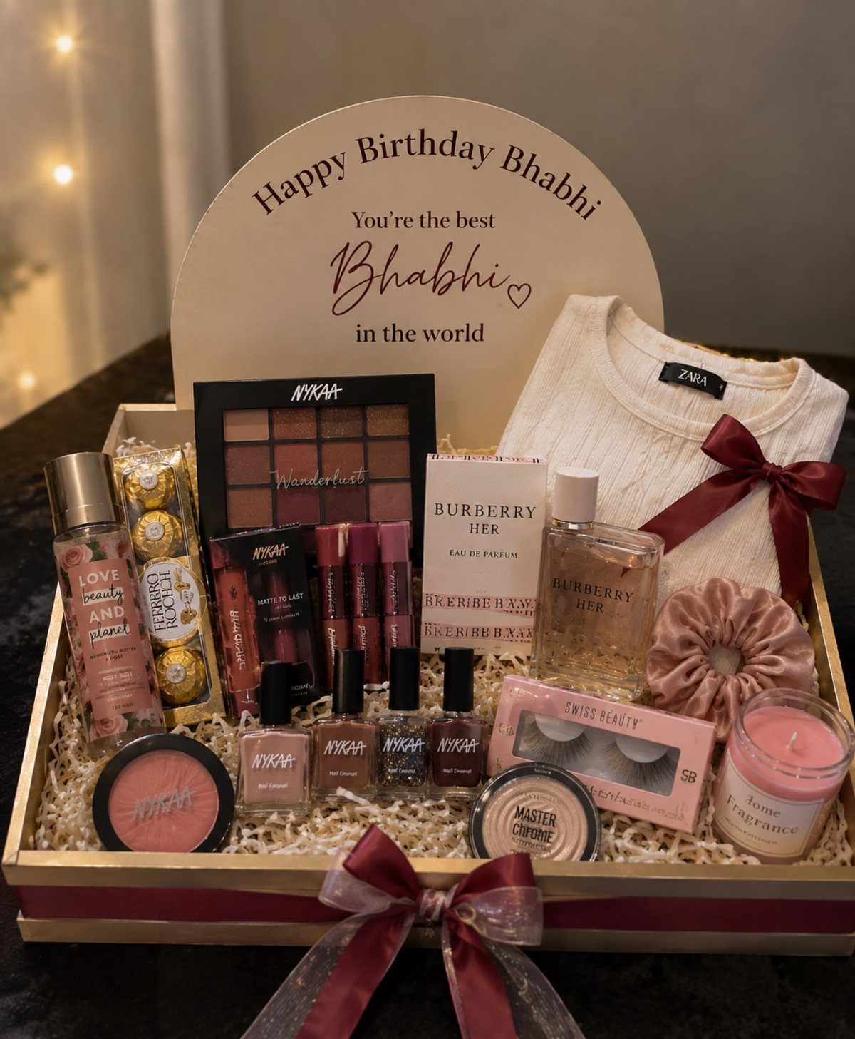 Birthday gift hamper for sister-in-law containing cosmetics, perfume, and a white sweater.