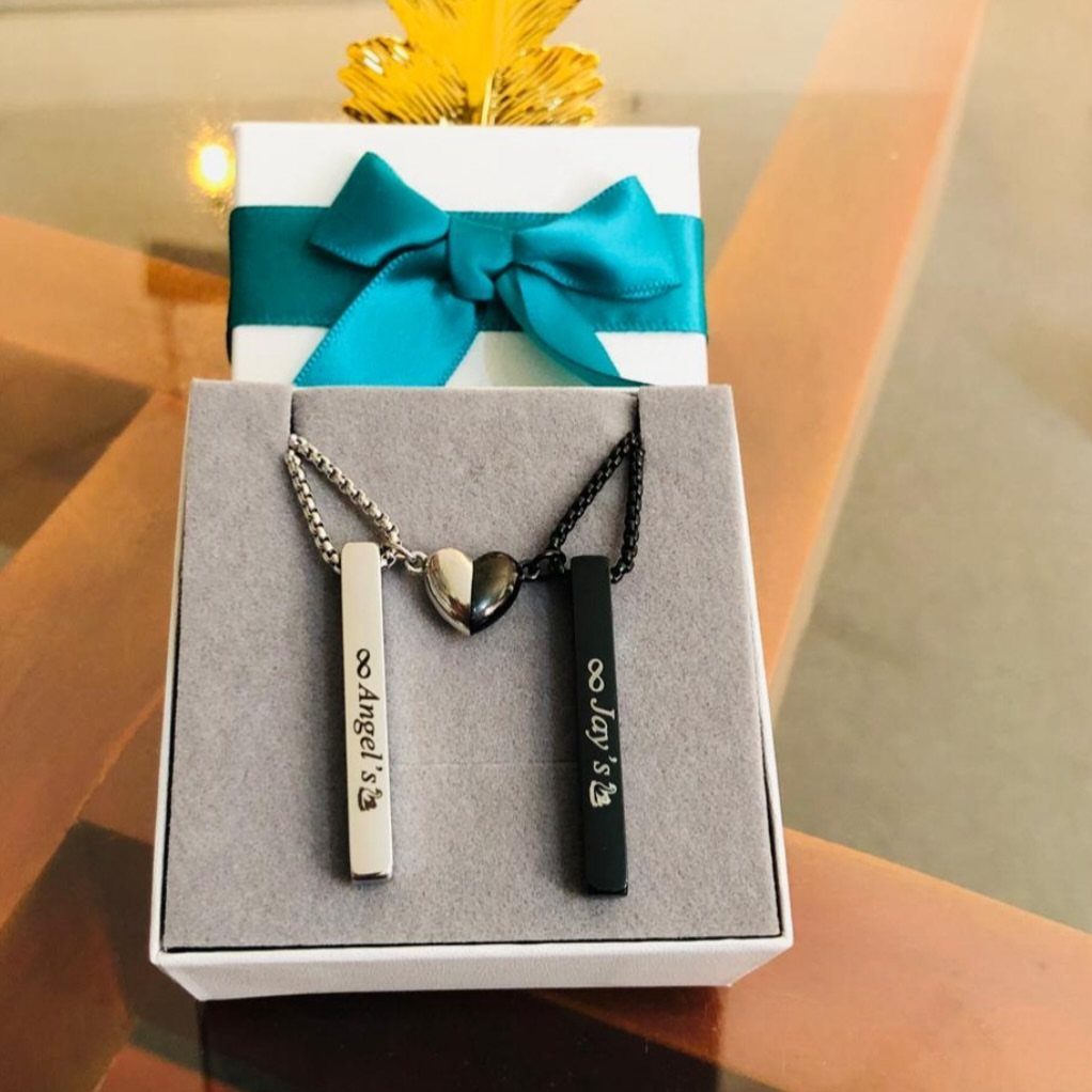 Matching silver and black bar necklaces with a heart pendant in a gift box