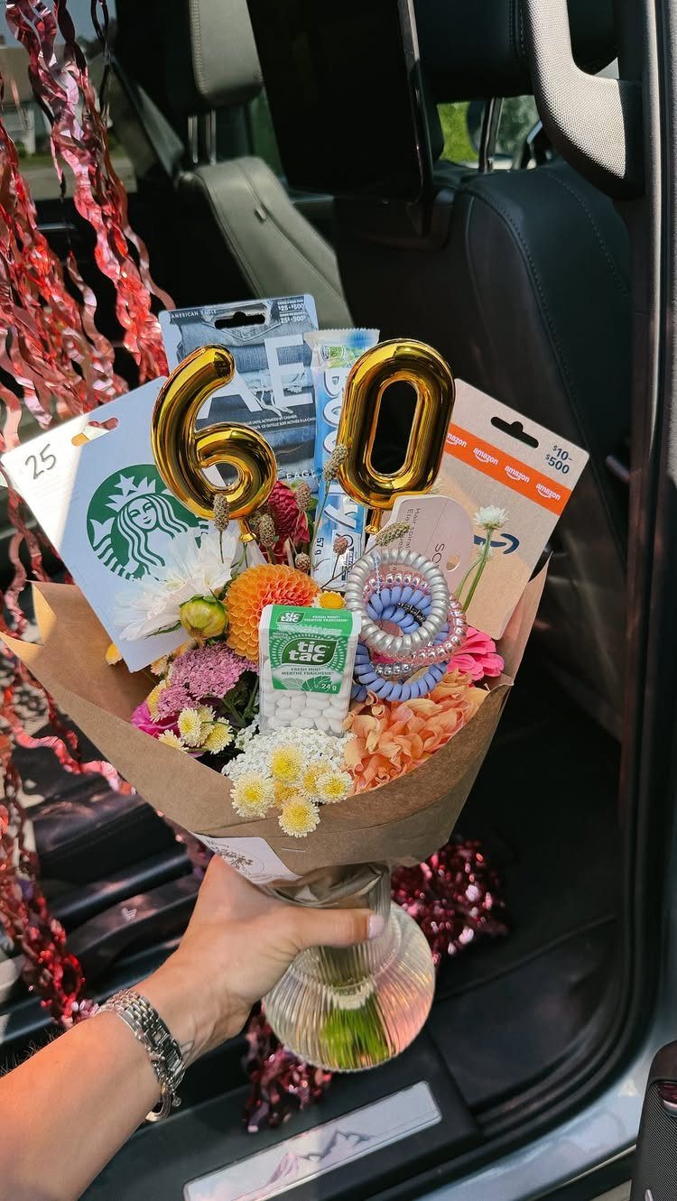 Bouquet of flowers and gift cards with gold 60 balloons for a birthday.