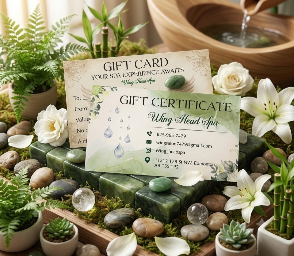 Spa gift cards surrounded by white flowers, green stones, and small potted plants.