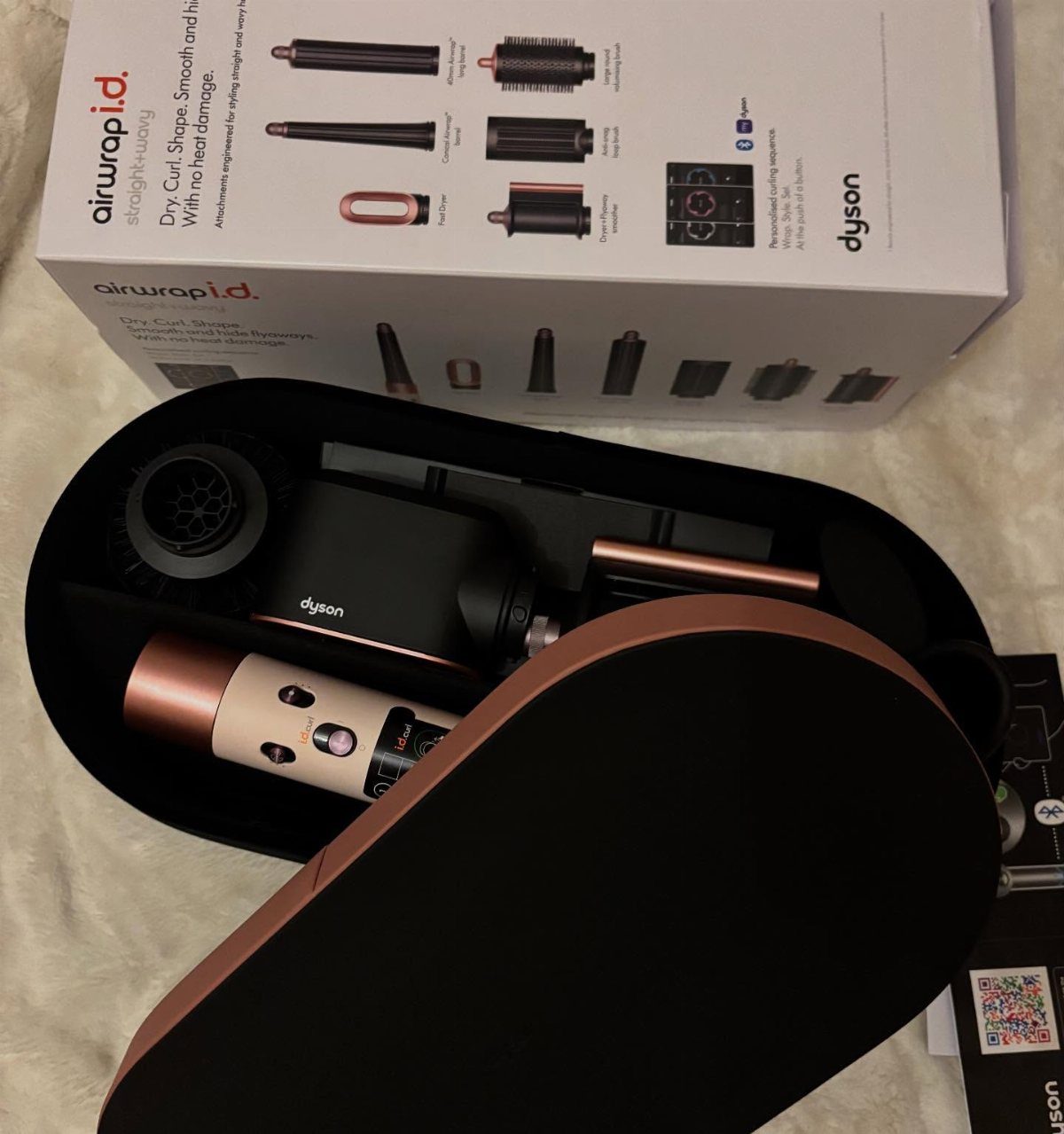 Dyson Airwrap hair styler and attachments in a black case with product box.