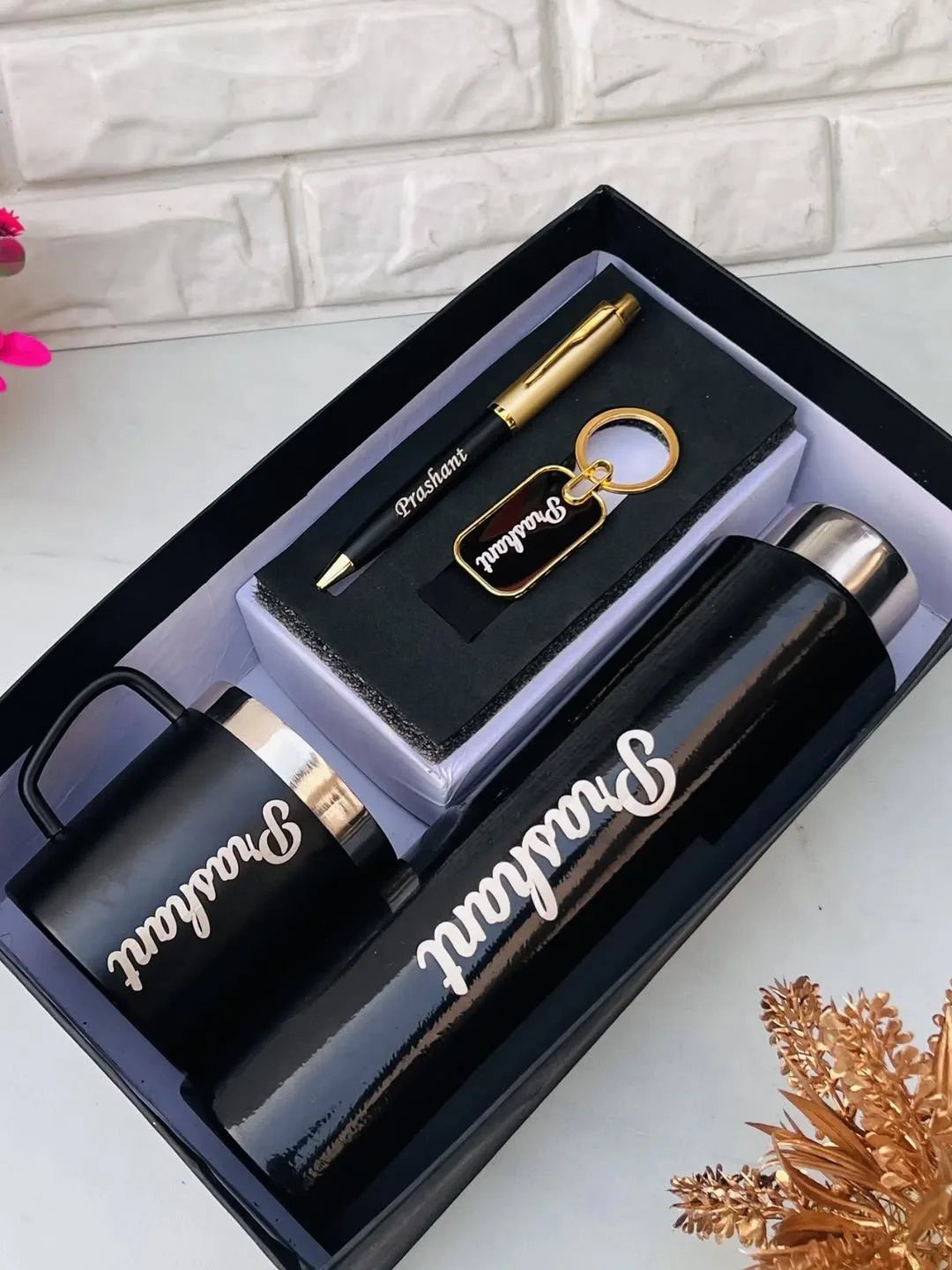 Personalized black gift set with engraved mug, thermos, pen, and keychain in box.