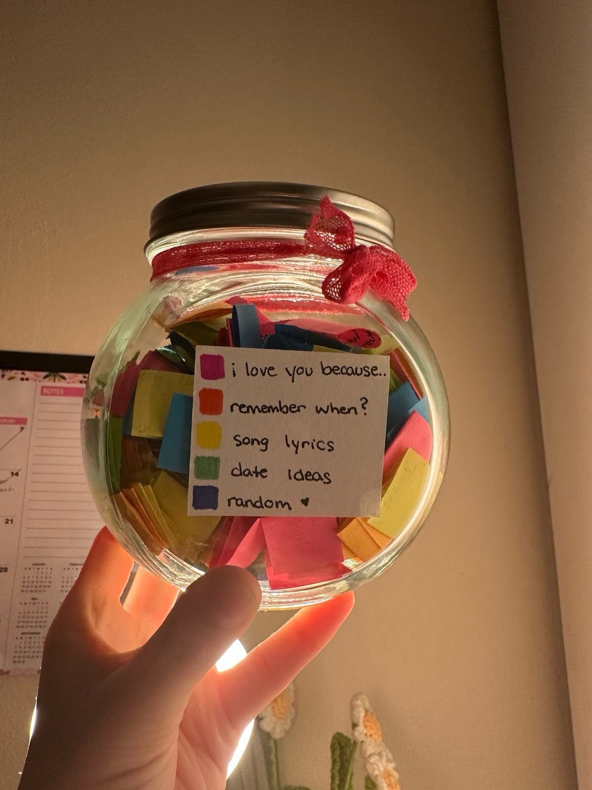 Glass mason jar filled with colorful notes and a handwritten category label.