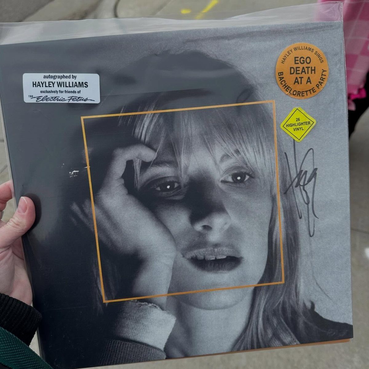 Vinyl record sleeve with a black and white portrait and yellow stickers.