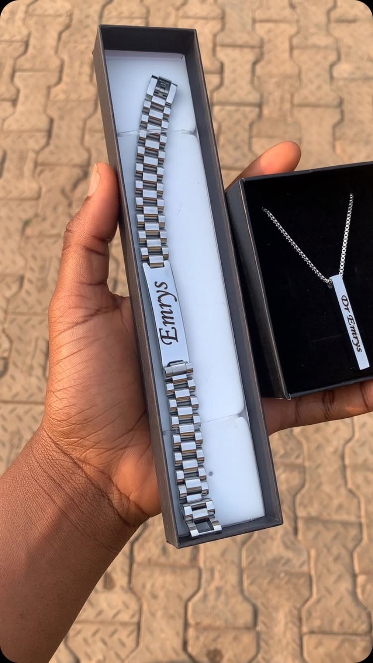 Silver engraved link bracelet and matching necklace in black gift boxes held by hand