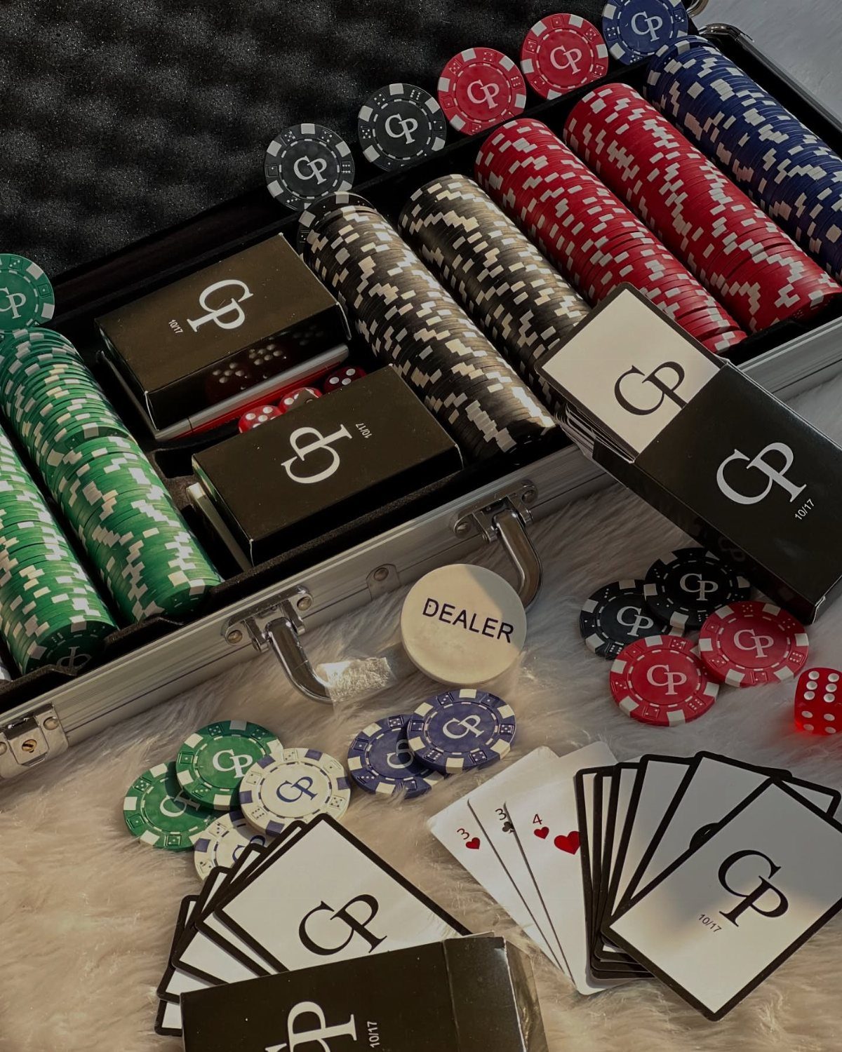 Custom poker set with GP logo on chips, cards, and black decks in case.