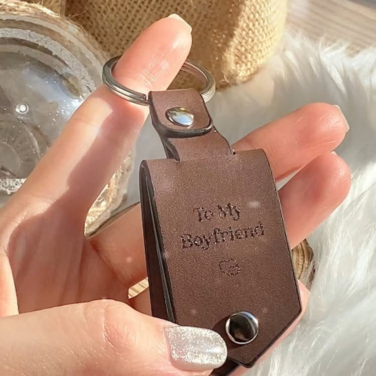 Brown leather keychain embossed with To My Boyfriend held by a hand