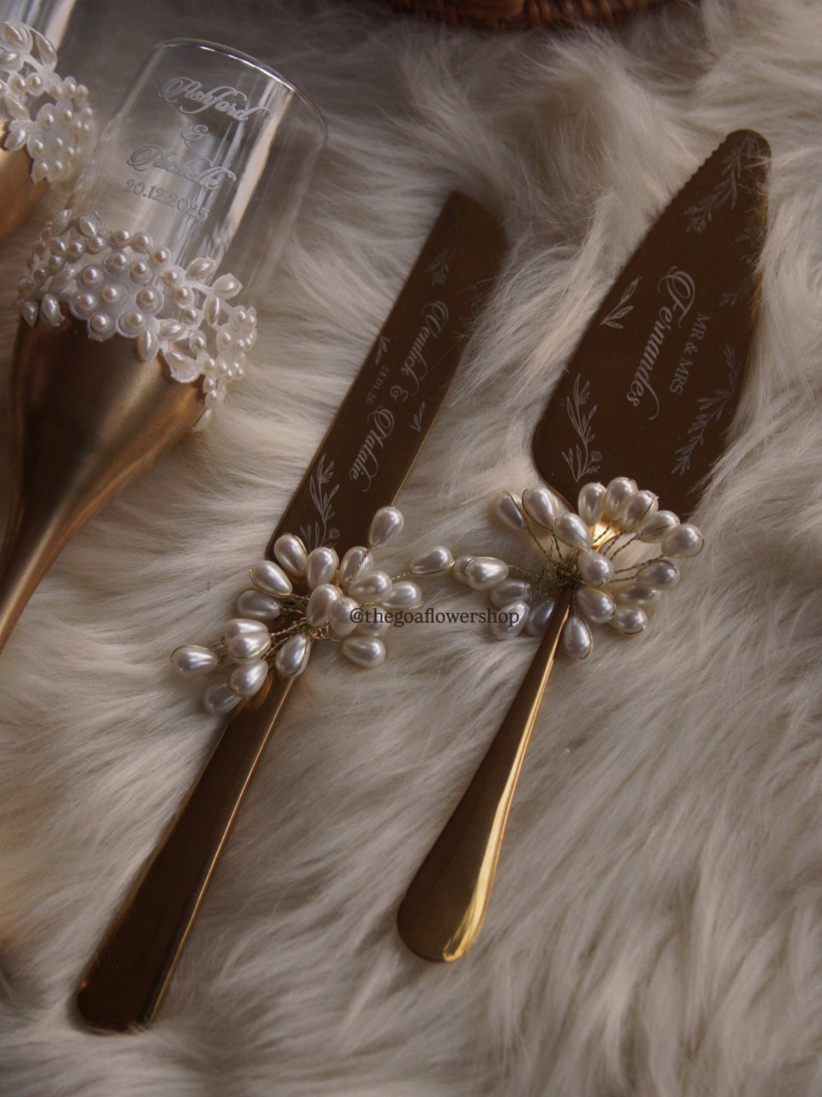 Gold cake server and knife set with pearl accents on white faux fur.