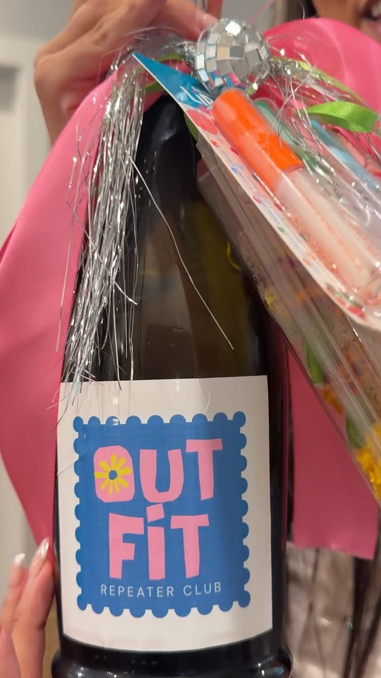 Customized wine bottle with Outfit Repeater Club label in a pink gift wrap