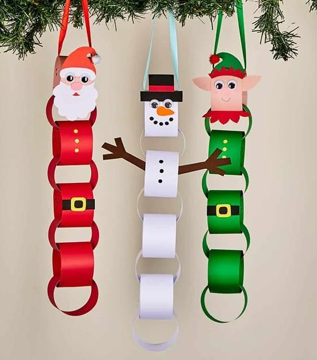 Santa, snowman, and elf decorations made from colorful paper loops hanging from branches