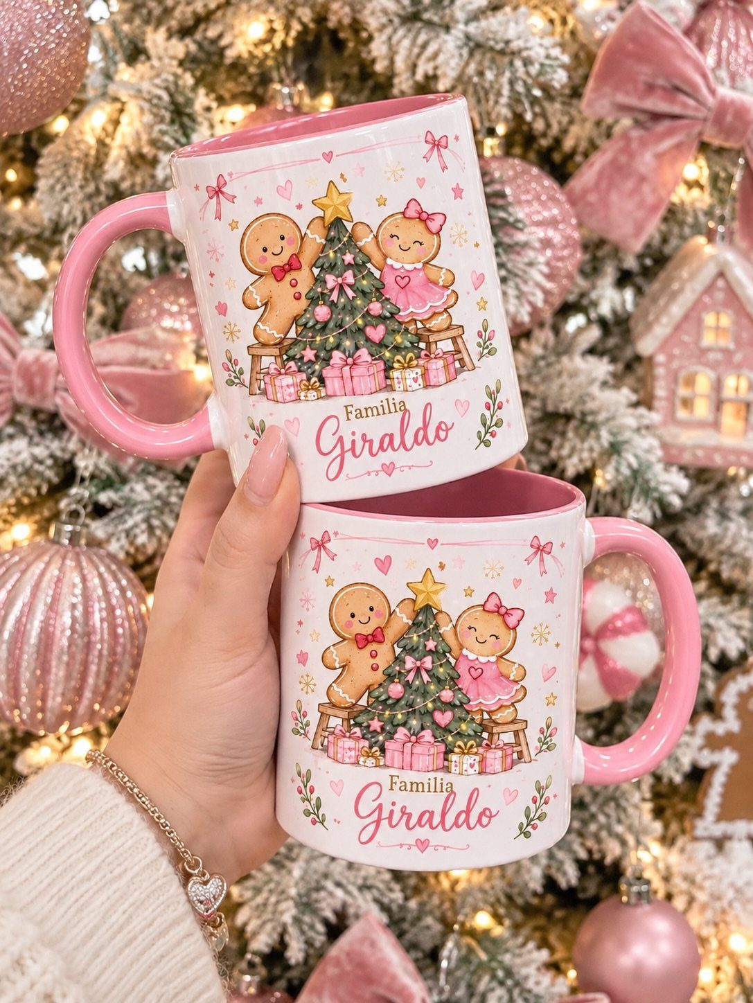 Two personalized Christmas mugs with gingerbread illustrations held against a decorated tree.