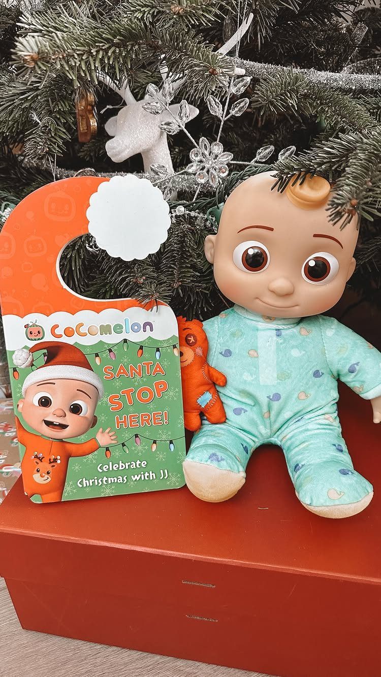 CoComelon Christmas board book and JJ plush doll under a decorated Christmas tree