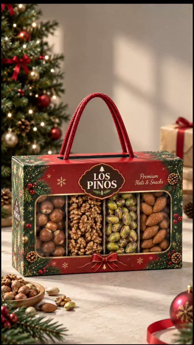 Red festive gift box filled with assorted nuts in front of a Christmas tree