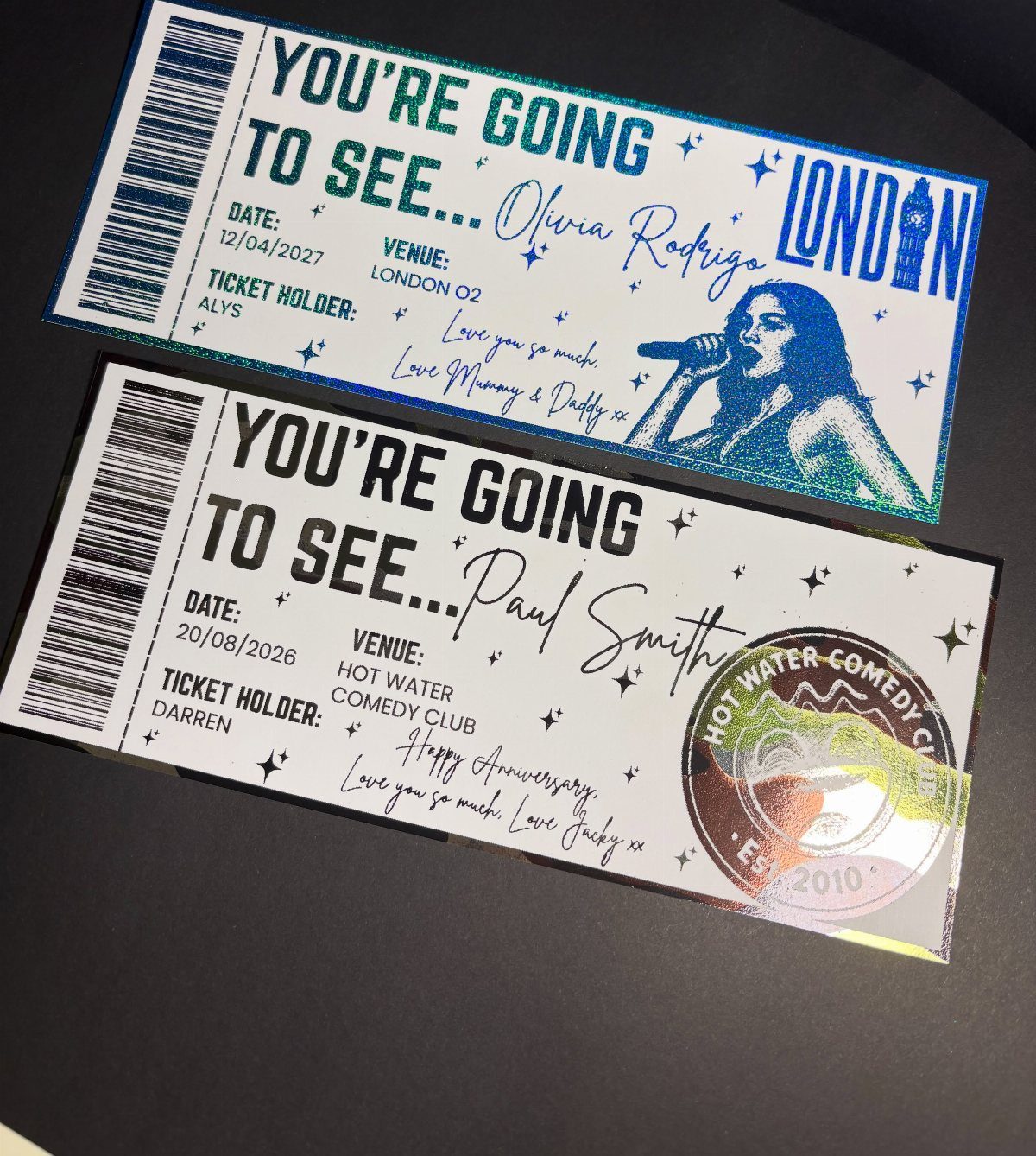 Two printed event tickets for a concert and a comedy show on dark background