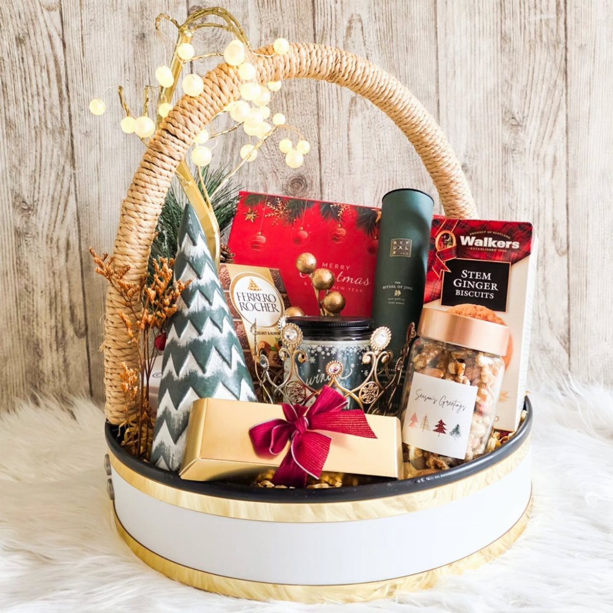 Gourmet food gift basket with biscuits, nuts, and chocolates in a wicker basket.