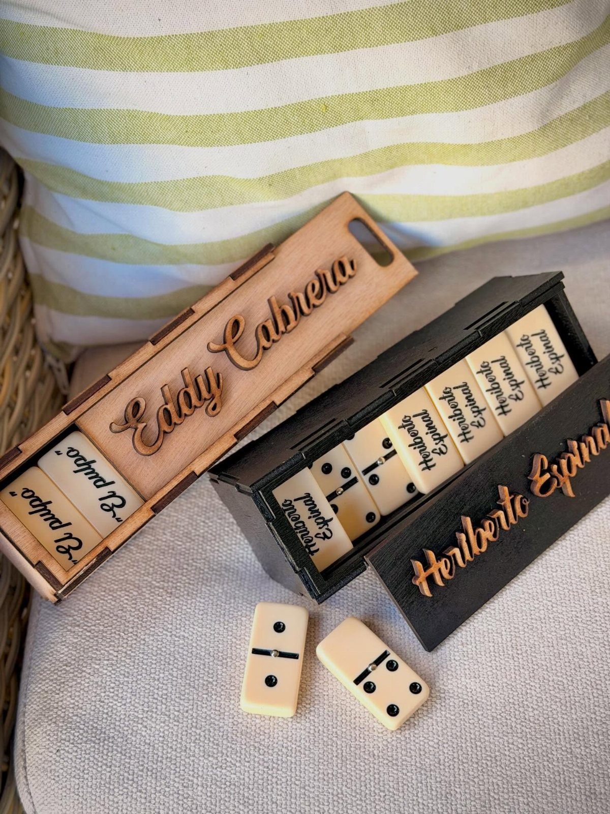 Personalized wooden domino sets with engraved names on boxes and printed tiles.