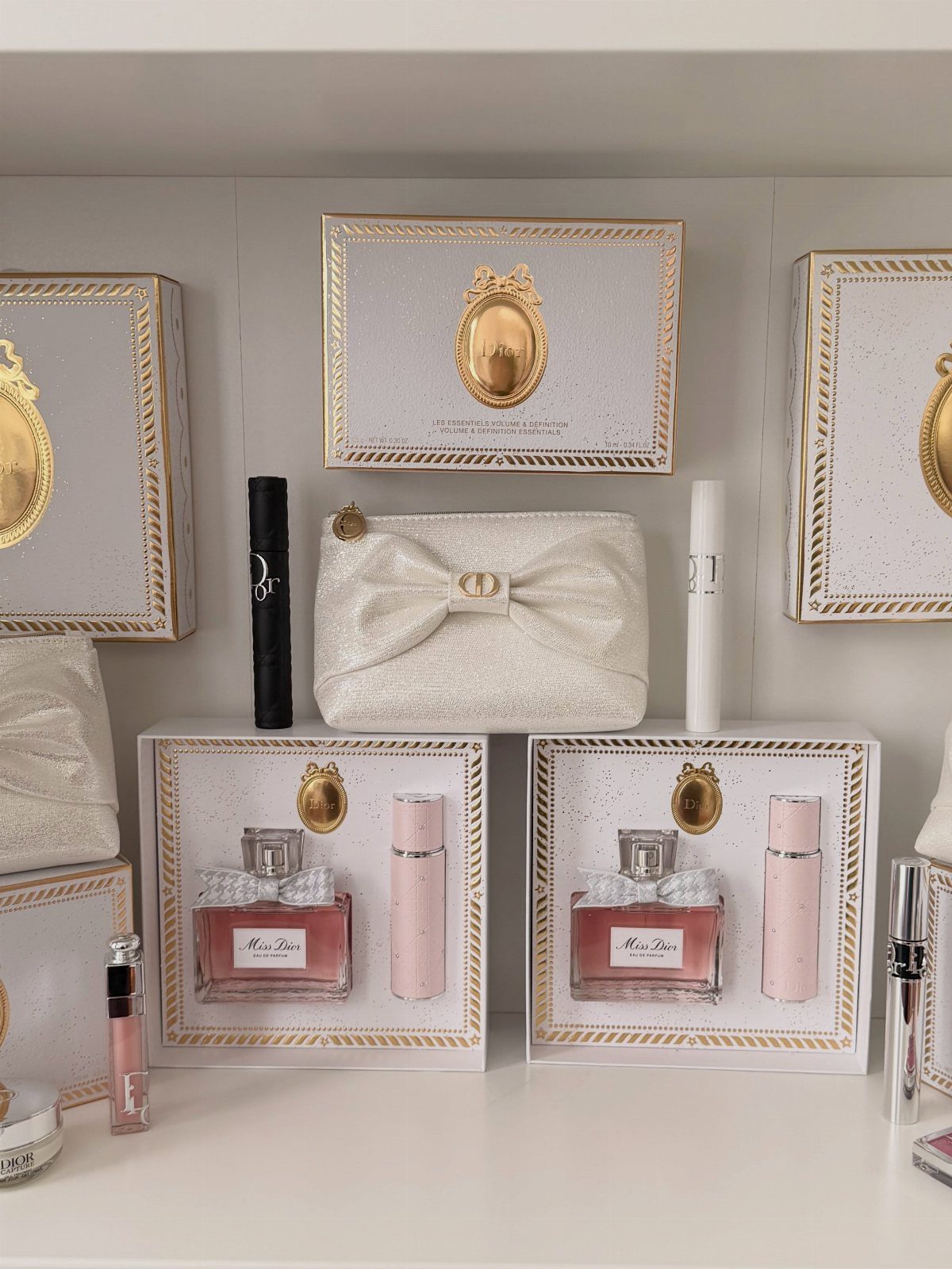 Luxury Dior perfume gift sets and beauty products arranged on a white shelf.