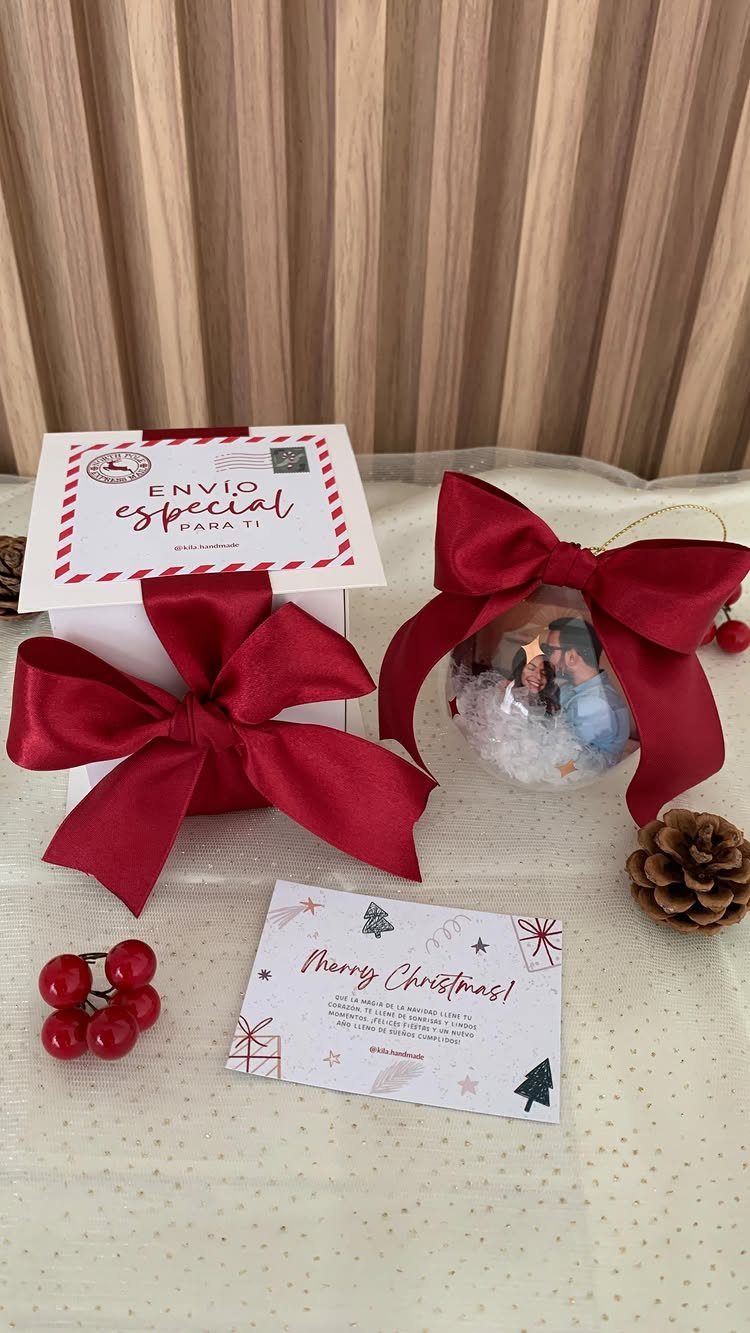 Glass ball ornament with a photo inside and a large red satin bow.