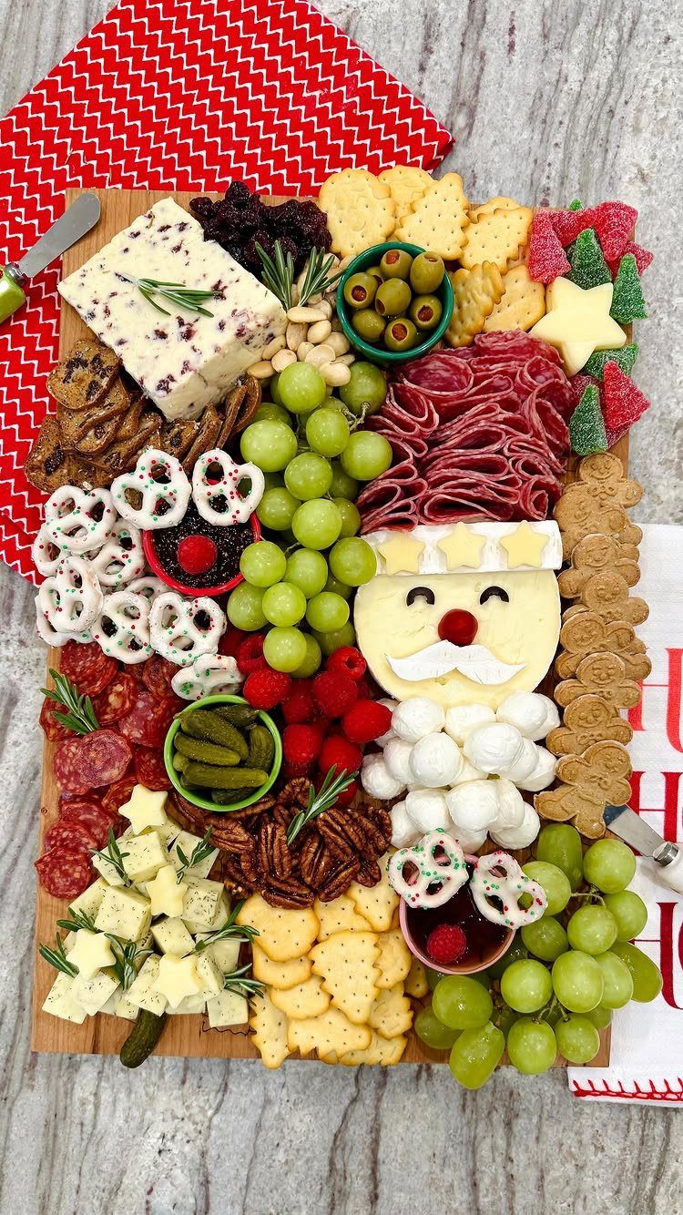 Christmas themed charcuterie board with meats, cheeses, and fruits arranged as Santa Claus.