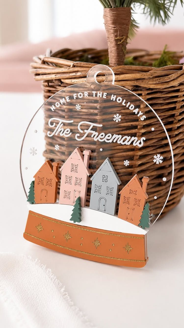 Personalized acrylic Christmas ornament with colorful houses and the name The Freemans.