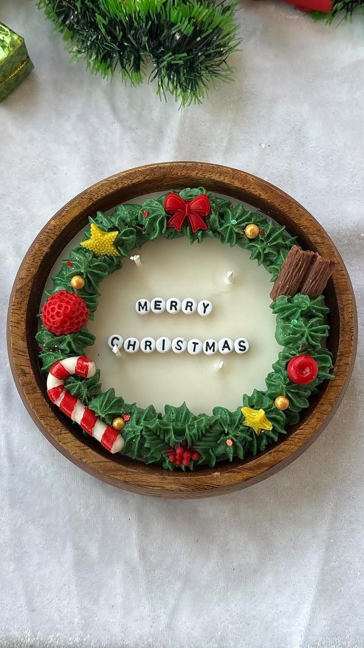 Christmas candle in a wooden bowl with a green wax wreath and lettering