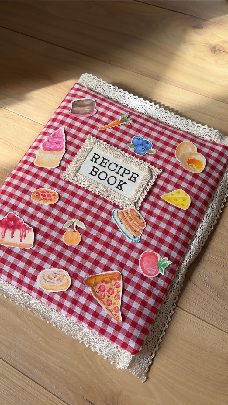 Handmade recipe book with red checkered fabric, lace trim, and food illustrations.