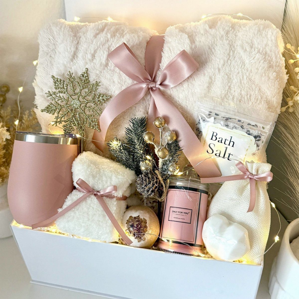 Spa gift box with white robe, pink tumbler, candle, and bath salts.