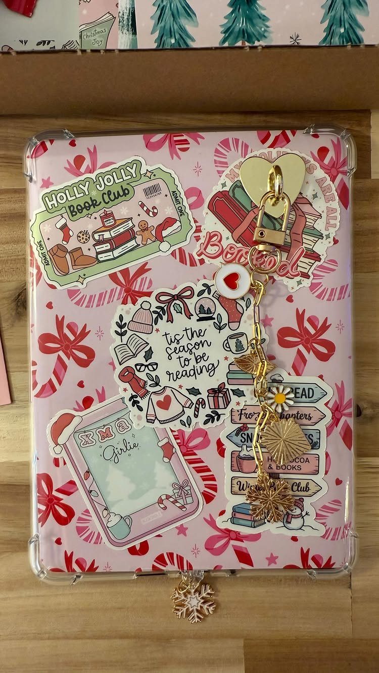Decorated pink tablet case with Christmas book stickers and gold heart charms.