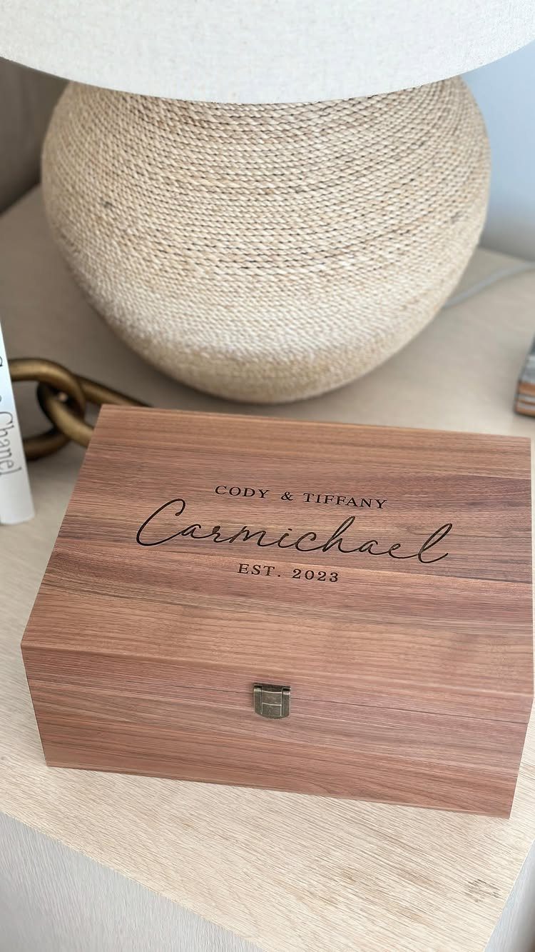 Engraved cherry wood keepsake box with the name Carmichael on a table