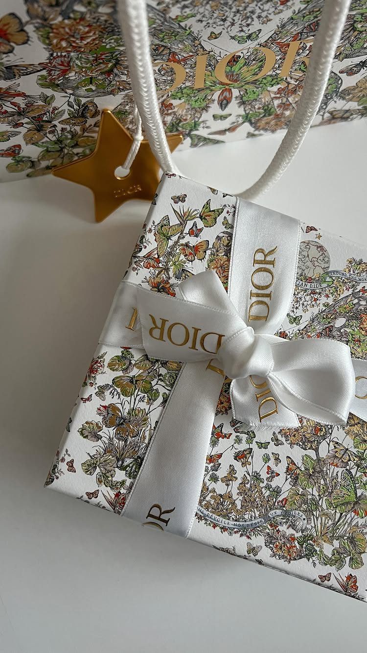 Dior gift box with floral wrapping and white ribbon on white background
